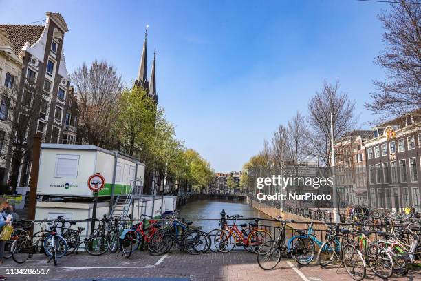 Scenic of Bike Bicycle lining on the bridge over canal Amsterdam in The Netherlands, with traditional houses over the water and Amsterdam canal. The...