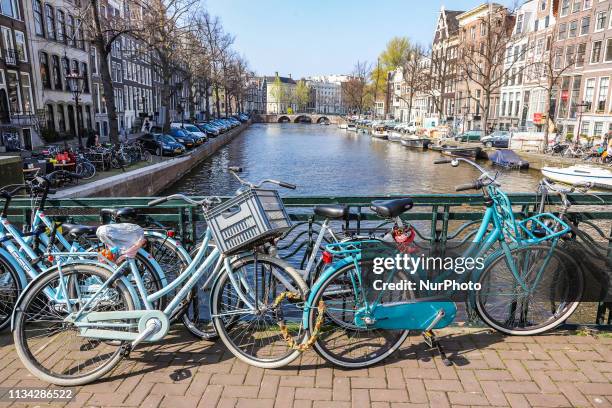 Scenic of Bike Bicycle lining on the bridge over canal Amsterdam in The Netherlands, with traditional houses over the water and Amsterdam canal. The...