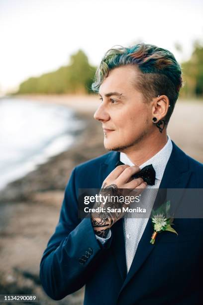 bridegroom with hand tattoo looking out from lakeside - buttonhole flower stock pictures, royalty-free photos & images