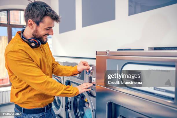 young man washing his clothes - money laundery stock pictures, royalty-free photos & images