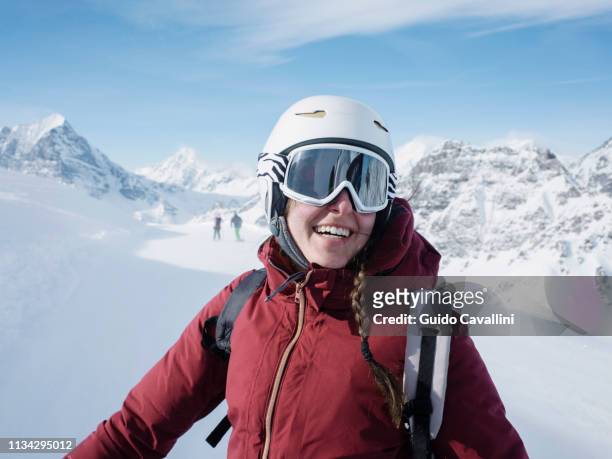 young woman skier wearing helmet and ski goggles smiling in snow covered landscape,  portrait, alpe ciamporino, piemonte, italy - piedmont stock photos et images de collection
