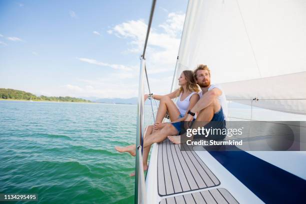 young couple sailing on chiemsee lake, bavaria, germany - chiemsee stockfoto's en -beelden