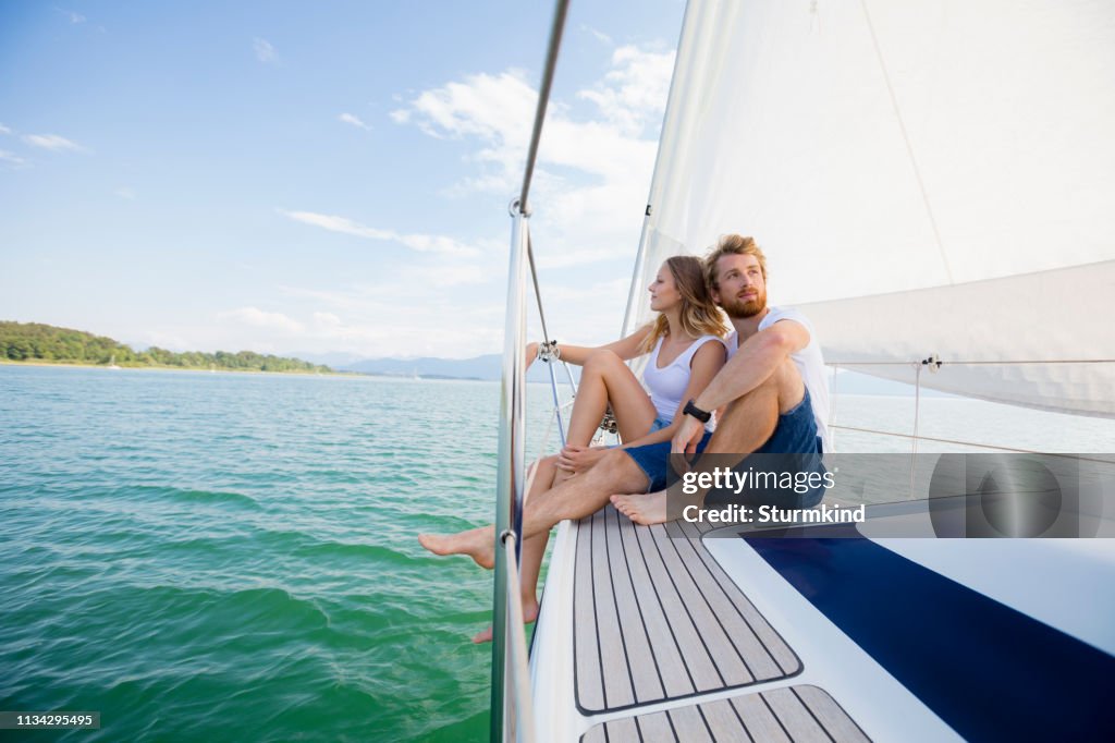 Young couple sailing on Chiemsee lake, Bavaria, Germany
