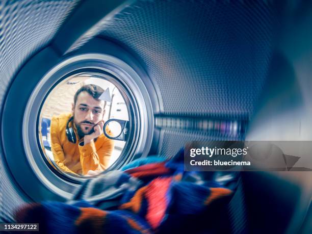 young man washing his clothes - man waiting stock pictures, royalty-free photos & images