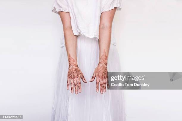 woman in white dress with henna tattoo on hands - henné photos et images de collection