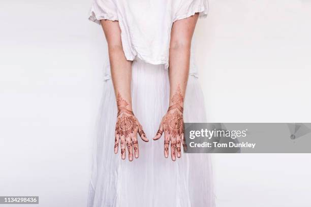 woman in white dress with henna tattoo on hands - mehndi stock pictures, royalty-free photos & images