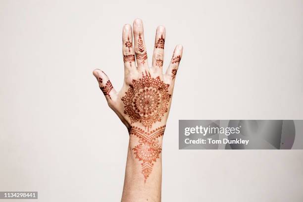 hand with henna tattoo making gesture - henna stockfoto's en -beelden