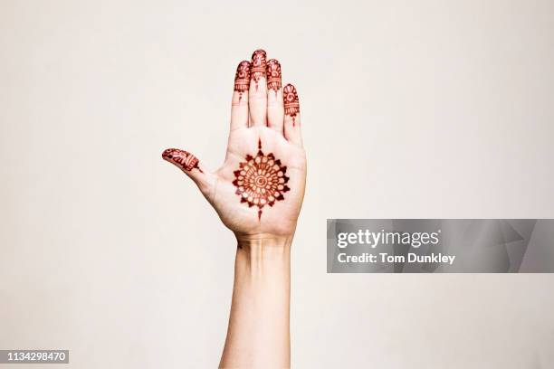 hand with henna tattoo making gesture - henna hands stock-fotos und bilder