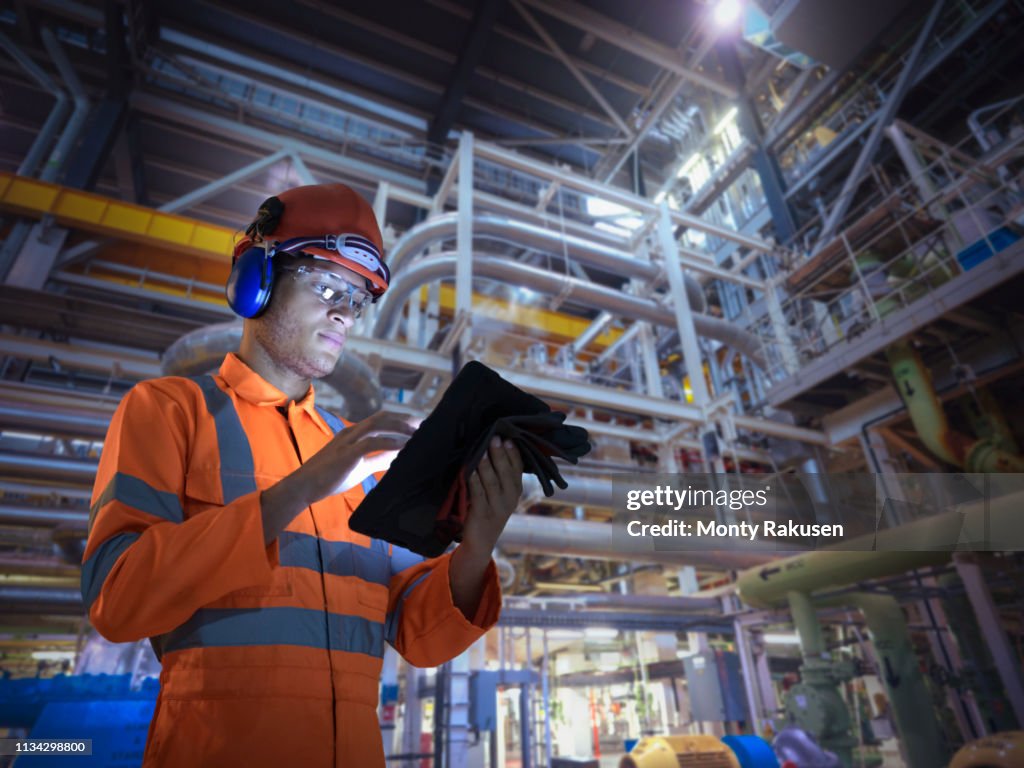 Composite image of engineer in nuclear power station using digital tablet