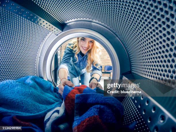 jovencita teniendo un día de lavandería - laundromat fotografías e imágenes de stock