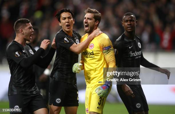 Kevin Trapp of Eintracht Frankfurt is congratulated by his team mates Luka Jovic of Eintracht Frankfurt, Makoto Hasebe of Eintracht Frankfurt and...