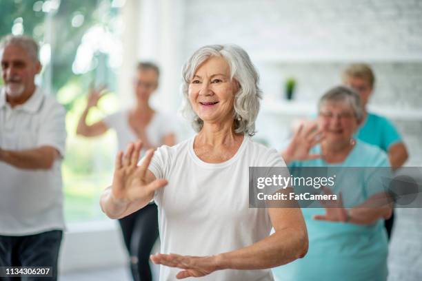 doing tai chi - active seniors indoors stock pictures, royalty-free photos & images