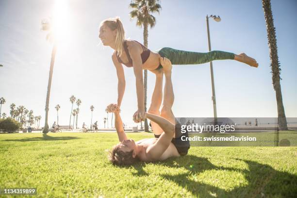 joyful people practicing acroyoga outdoors - acroyoga stock pictures, royalty-free photos & images