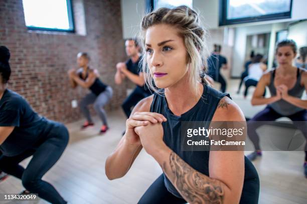 diverse fitness klasse doen squats - training class stockfoto's en -beelden