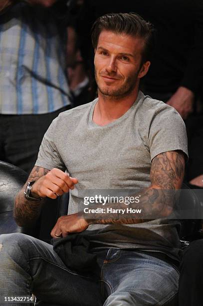 Soccer player David Beckham reacts in the first half as he sits courtside in Game Five of the Western Conference Quarterfinals in the 2011 NBA...