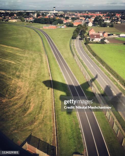 shadow of airplane landing - airplane shadow stock pictures, royalty-free photos & images