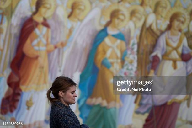 Woman walks past a mural outside Saint Michael's Golden-Domed Monastery in Kyiv, Ukraine on April 1, 2019.