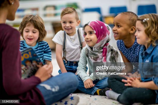 teacher reading a book - teacher pre school imagens e fotografias de stock