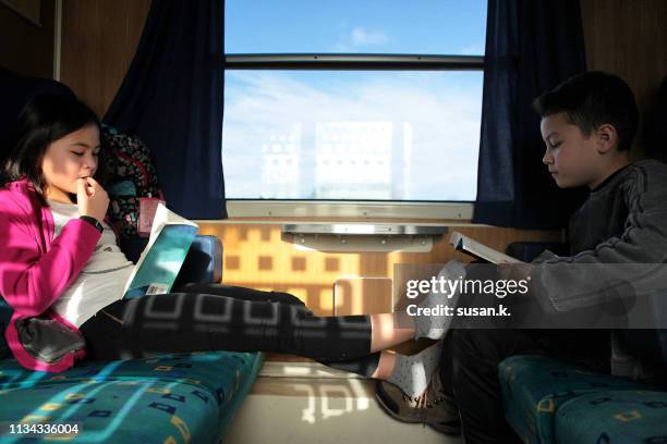 portrait of girl and boy reading book on the train. - school hungary stock pictures, royalty-free photos & images