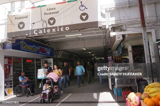 Pedestrians walk into Mexicali, Mexico from Calexico, California at the Port of Entry on April 1, 2019. - US President Donald Trump announced the aid...