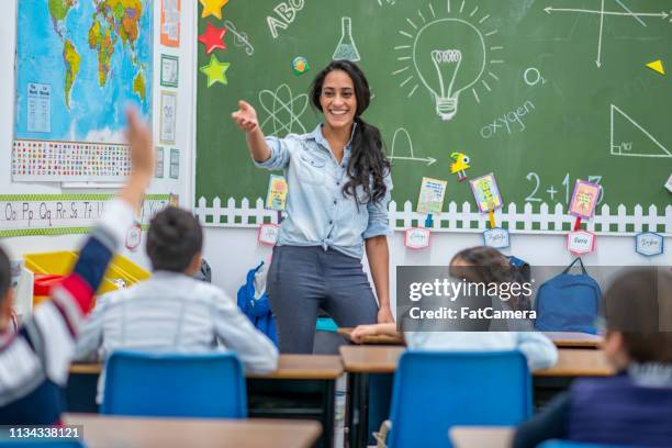 students answering a question - kids in classroom desks stock pictures, royalty-free photos & images