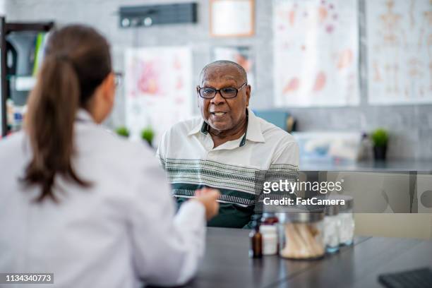 considering prescriptions from a doctor - critical illness stock pictures, royalty-free photos & images