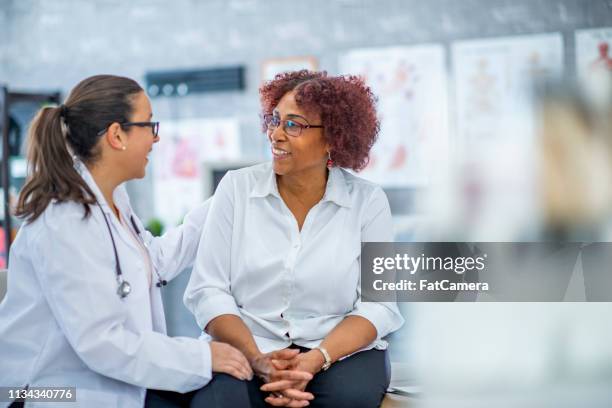 mujer de mediana edad visitando al médico - atención primaria fotografías e imágenes de stock