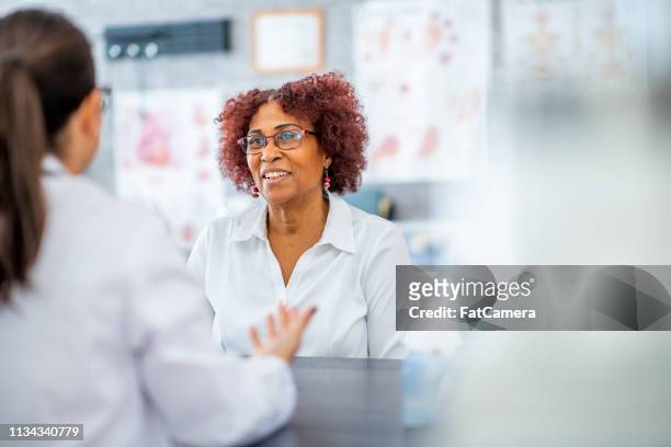 middle-aged woman visiting the doctor - diabetes pills stock pictures, royalty-free photos & images