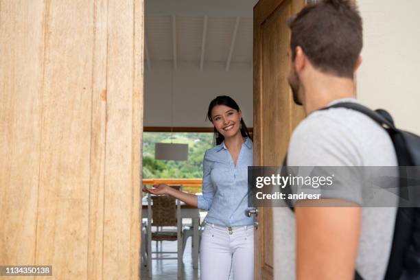 huis delen gastvrouw gastvrije gasten aan haar huis - hostesses stockfoto's en -beelden