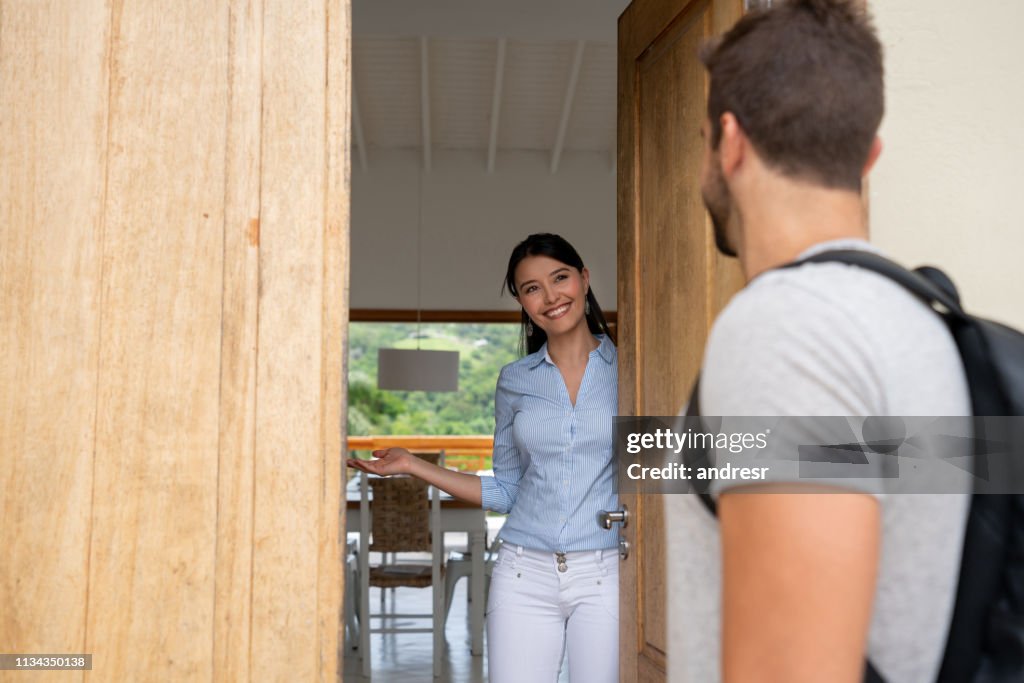 House sharing hostess welcoming guest to her house