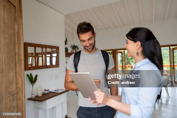 hostess di condivisione della casa che spiega le regole della casa a un ospite felice - party host foto e immagini stock