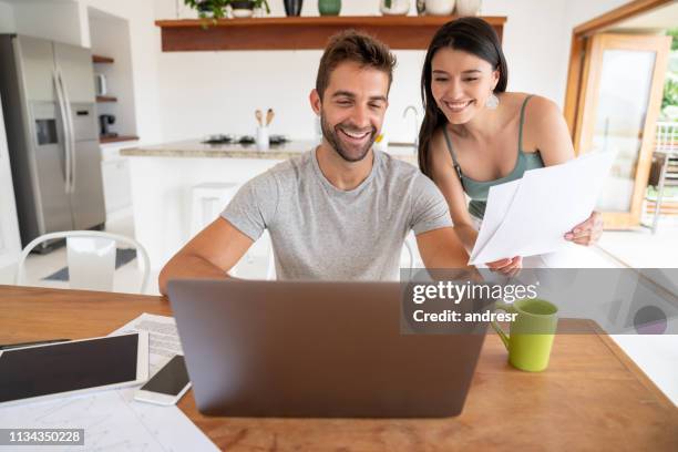 loving couple paying bills online at home - money on the move stock pictures, royalty-free photos & images