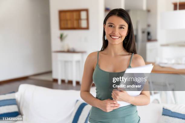 happy house sharing hostess at home holding documents - party host imagens e fotografias de stock