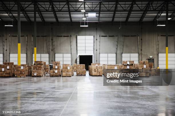 cardboard boxes at loading dock in warehouse - factory building exterior stock pictures, royalty-free photos & images