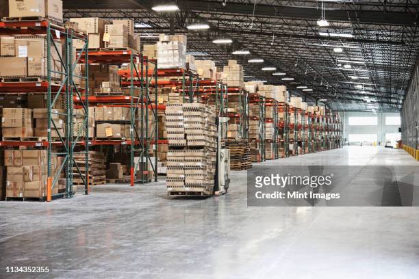 cardboard boxes on shelves in warehouse - building shelves stock-fotos und bilder