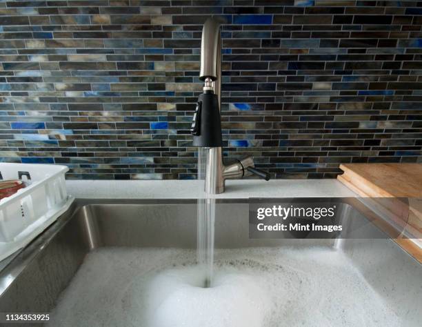 kitchen sink with soapy water - kitchen sink stock pictures, royalty-free photos & images