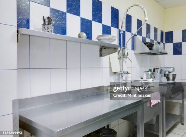 stainless steel counter and sink in empty restaurant kitchen - ステンレス ストックフォトと画像