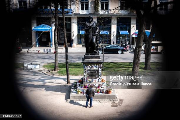 April 2019, Bavaria, München: A man stands in front of the monument to Orlando-di-Lasso, a Renaissance composer and Kapellmeister who was converted...