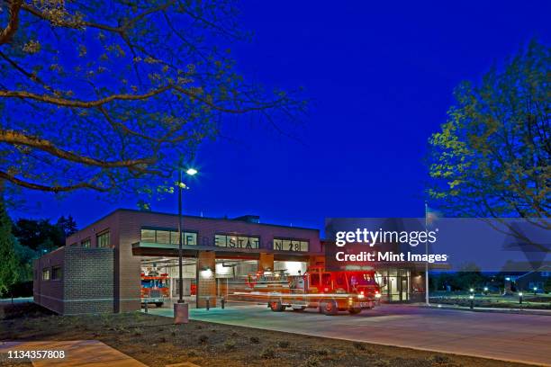 fire engine leaving a station at night - emergency response stock pictures, royalty-free photos & images