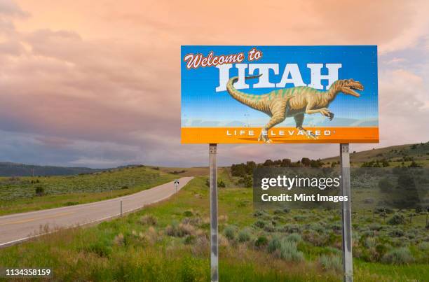 dinosaur on welcome to utah sign along road, utah, united states - borde de la carretera fotografías e imágenes de stock