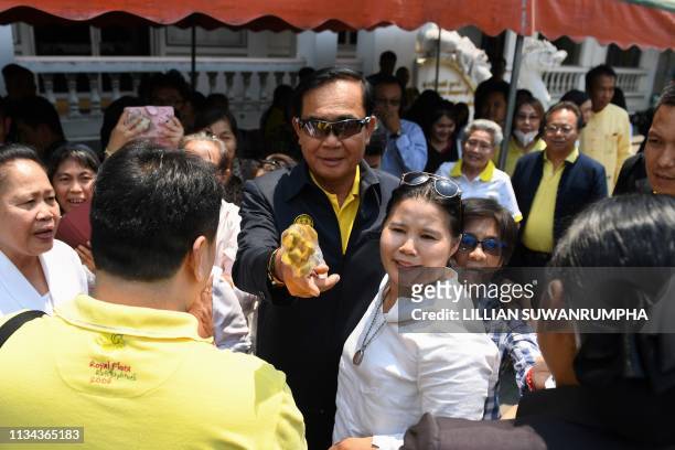Thailand's Prime Minister Prayut Chan-O-Cha speaks with supporters while visiting Wat Bupparam temple in the northern Thai province of Chiang Mai on...