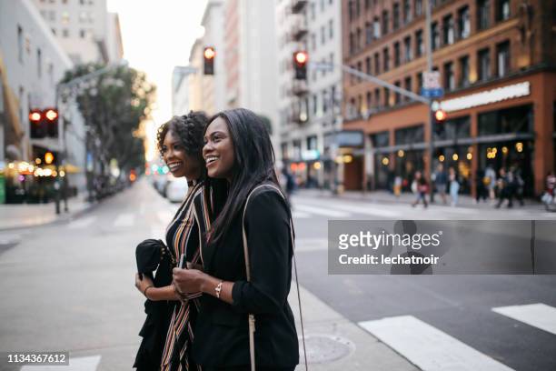 two young female friends walking in downtown los angeles - a la moda stock pictures, royalty-free photos & images