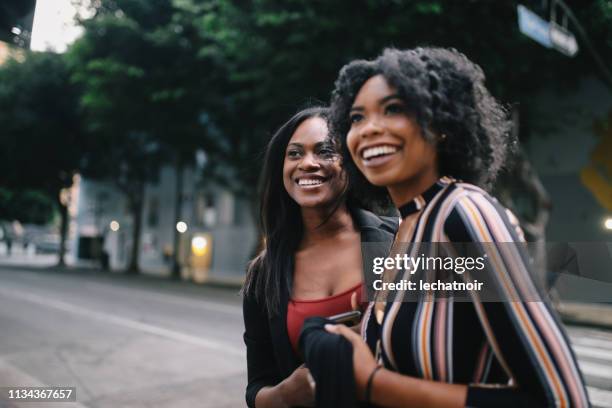 ロサンゼルスのダウンタウンを歩いている二人の若い女性の友人 - los angeles events ストックフォトと画像
