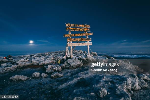 top of mt kilimanjaro with a full moon at sunrise - monte kilimanjaro fotografías e imágenes de stock