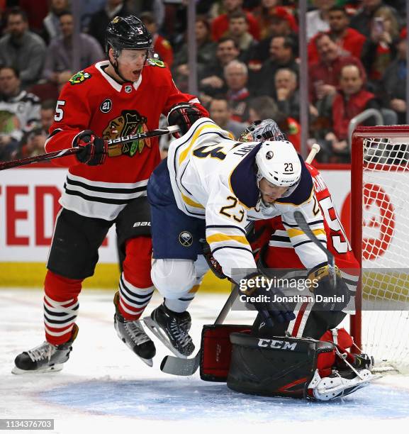 Sam Reinhart of the Buffalo Sabres falls over Corey Crawford of the Chicago Blackhawks as Connor Murphy defends at the United Center on March 07,...