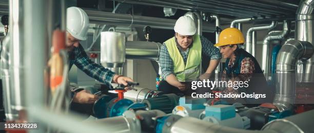 los técnicos que trabajan en fábrica o utilidad - servizio fotografico fotografías e imágenes de stock