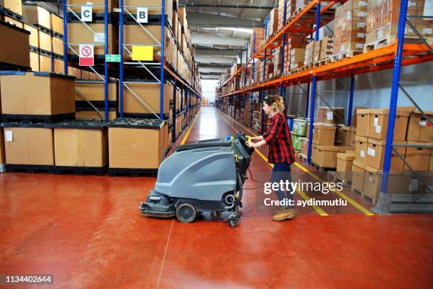 woman doing cleaning in warehouse - warehouse floor stock pictures, royalty-free photos & images