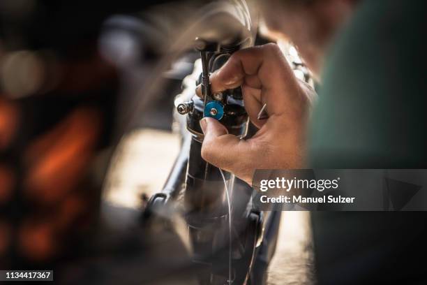 close up of young male mountain biker repairing bike - fahrrad reparieren stock-fotos und bilder