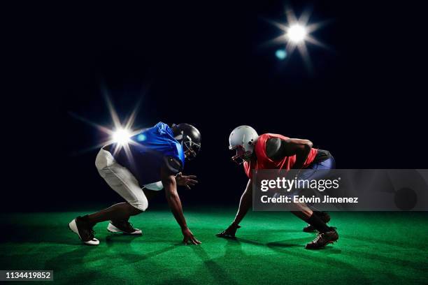two american footballers crouching - tackle stockfoto's en -beelden