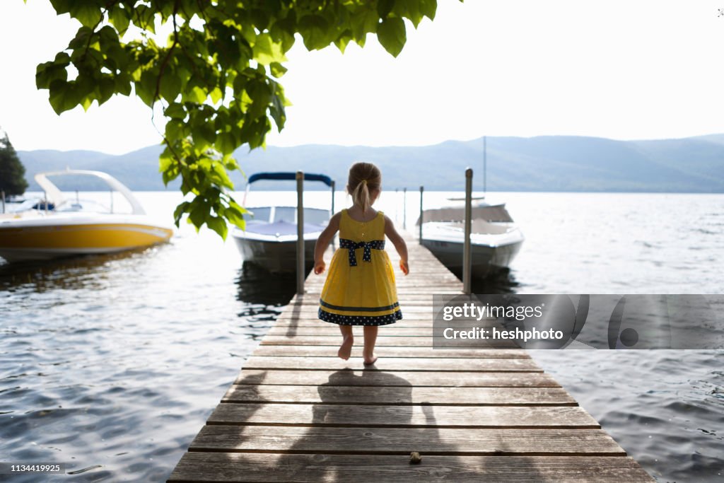 Female toddler exploring pier, Silver Bay, New York, USA